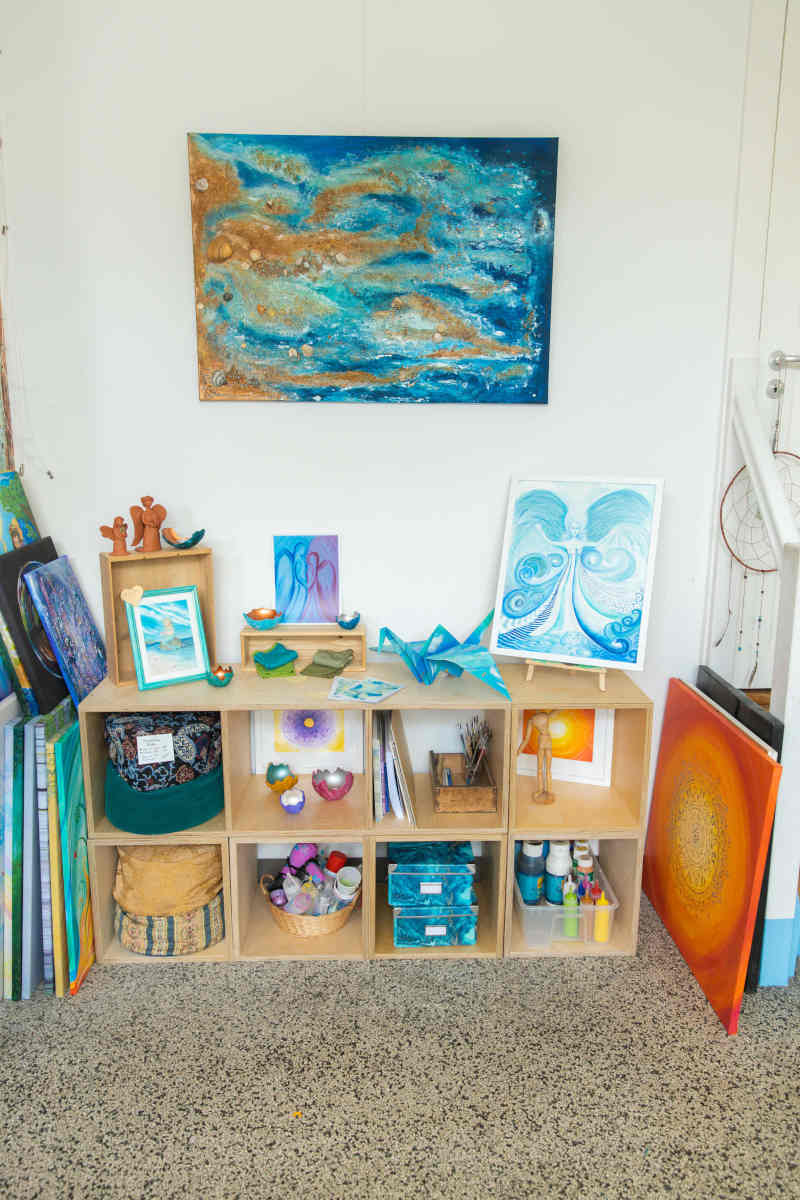 verkaufsregal im atelier mit bildern dekoration yogakissen